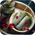 Two Indian Kulfi ice-cream sticks served with rose petals